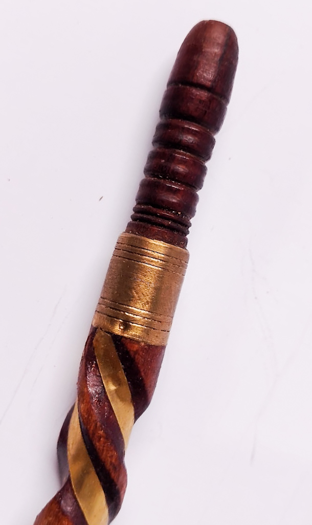 Deep red spiral-carved sebsi stem with a wide hammered brass collar